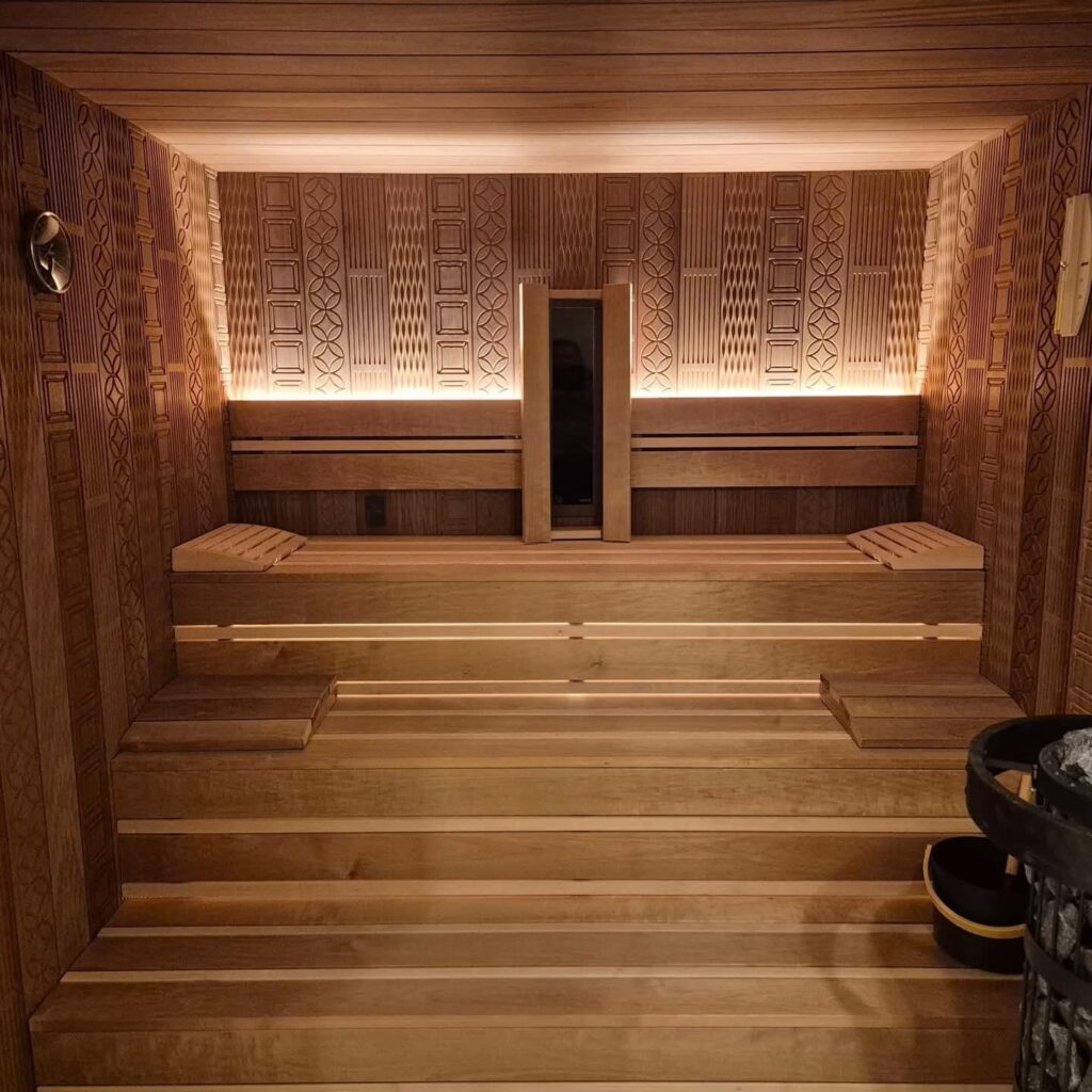 Custom-made indoor sauna with a backlit wall panel by Nordik Wellness