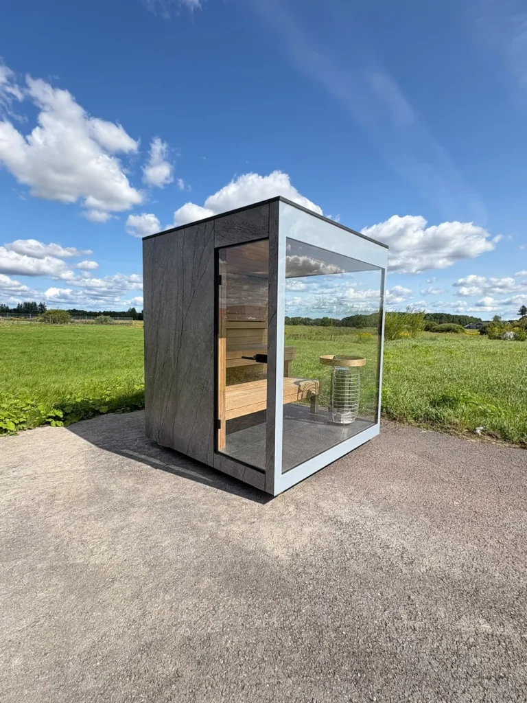 New outdoor sauna by Nordik Wellness with stone-effect cladding and a full-height glass front