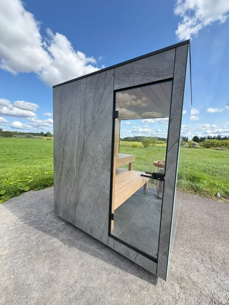 New Nordik Wellness outdoor sauna with the glass door open, showing the timber benches inside