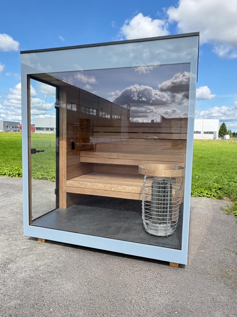 Glass front of a new Nordik Wellness outdoor sauna showing the tiered timber benches and heater