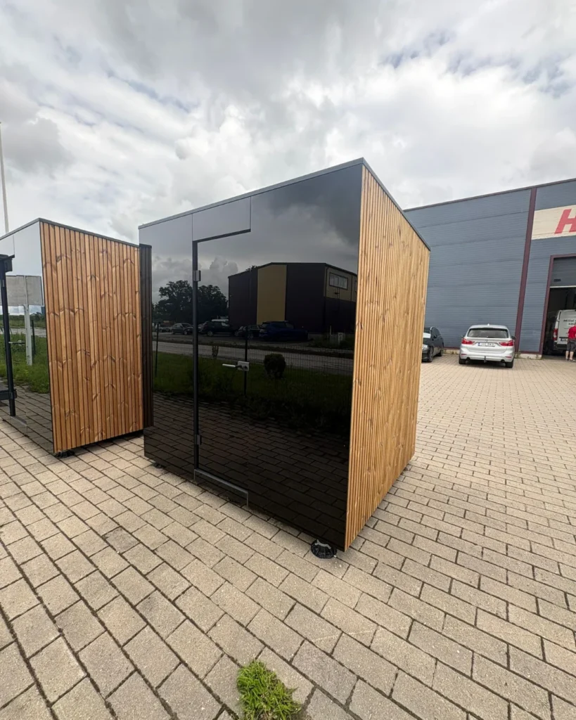 Signature M outdoor sauna with a full-height glass door and timber cladding by Nordik Wellness