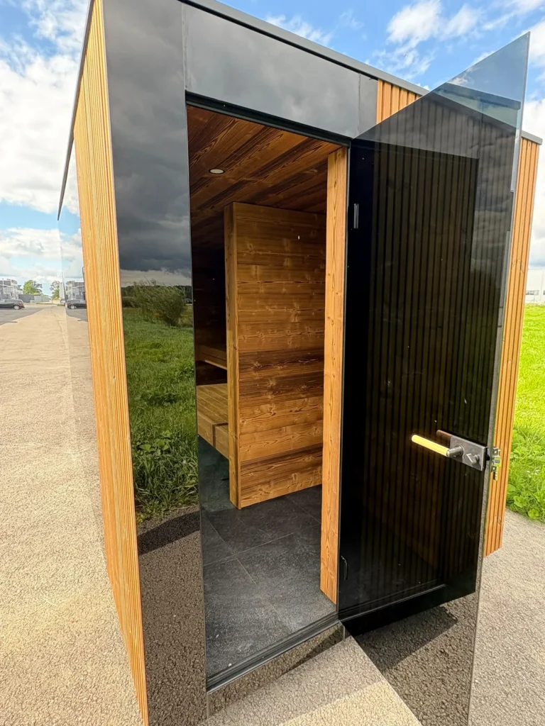 Signature L outdoor sauna with the door open, showing the timber interior