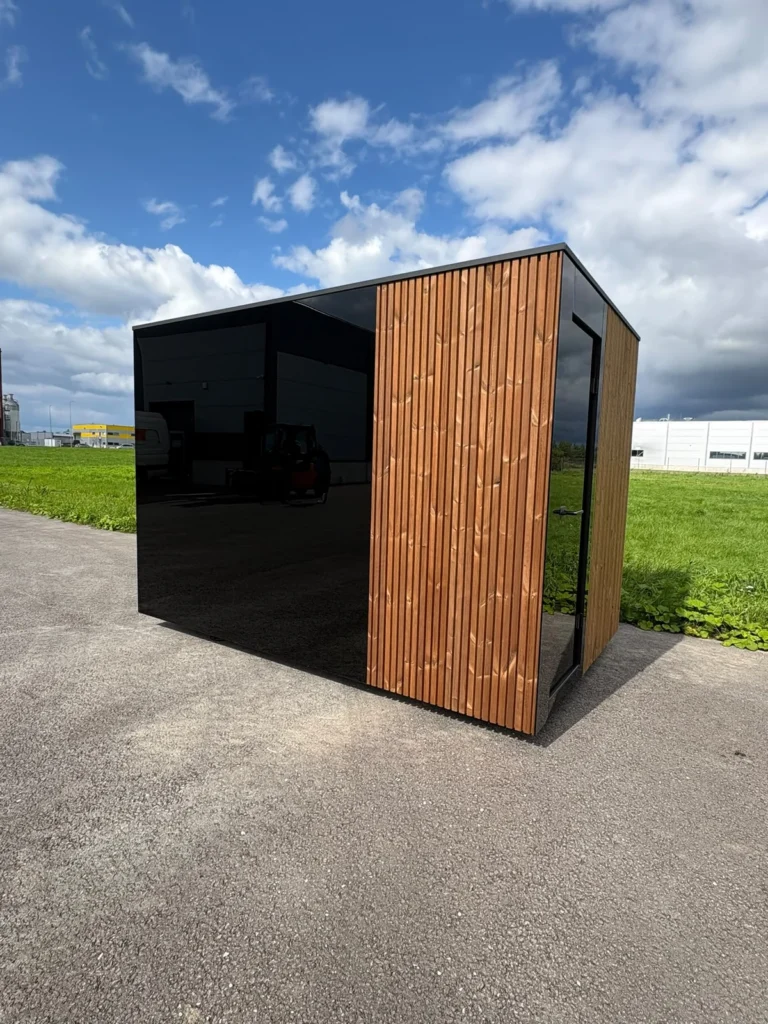 Signature L outdoor sauna with a black glazed end and timber-clad side