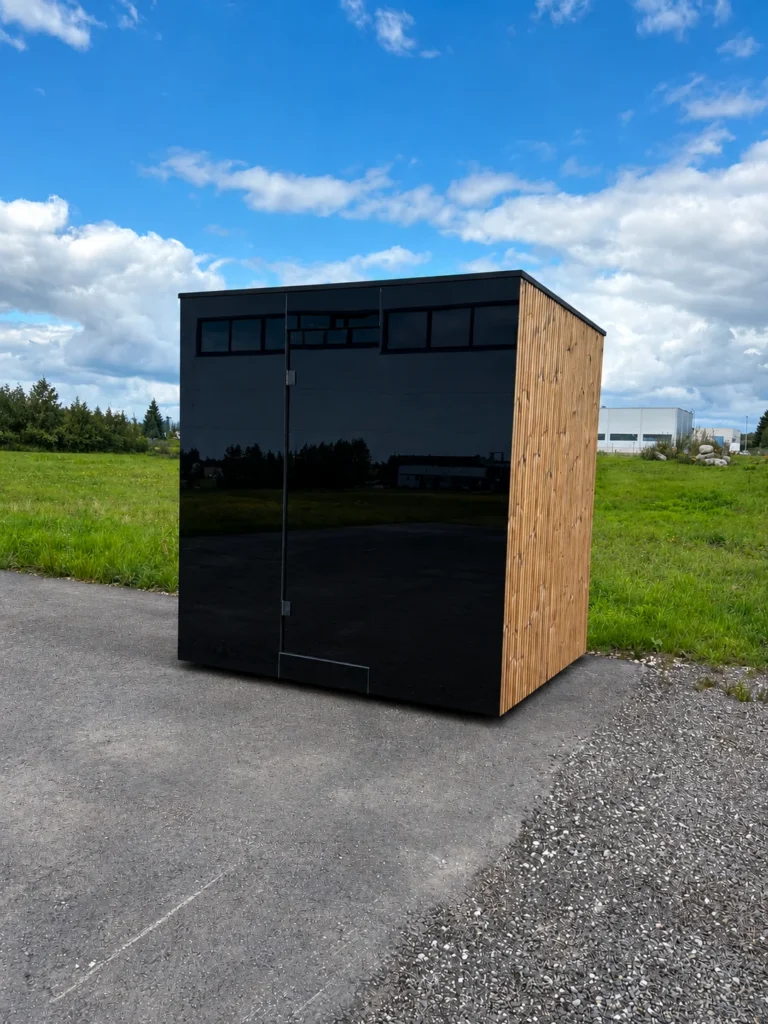 Signature M outdoor sauna with a black glazed front and timber-clad side